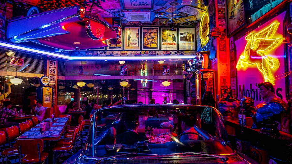 A lively retro diner bustling with people, neon lights, and classic car decor, set at night